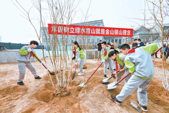 日前，在前门月亮湾绿地，各界代表和青少年共同参加植树，为北京再添新绿。 本报记者 邓伟摄