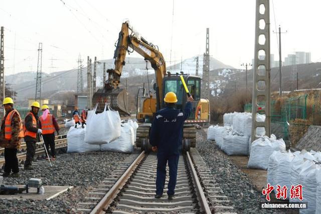 3月14日，兰州西工务段工作人员指挥挖机运送石砟。王光辉 摄