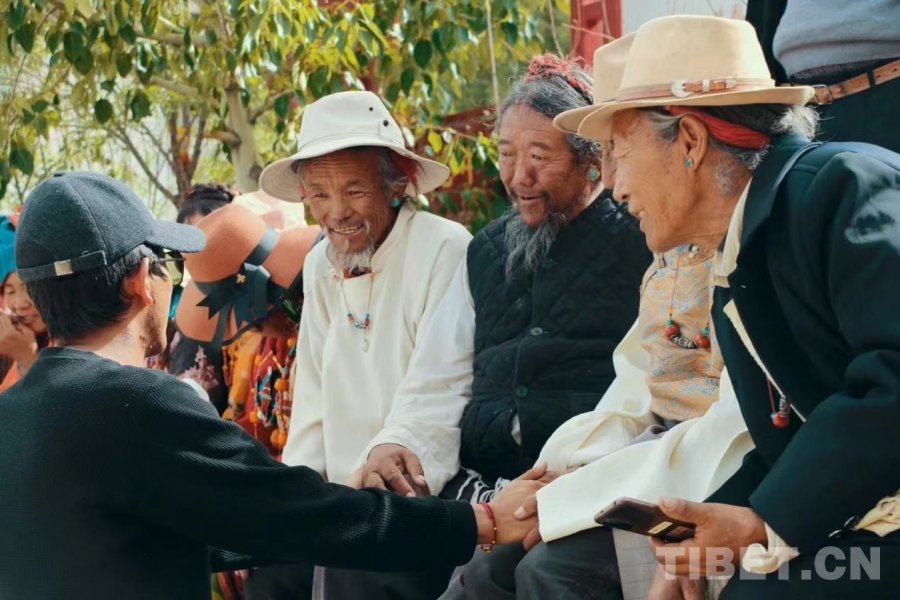 图为达瓦格桑（左）与长辈们聊天的温馨画面