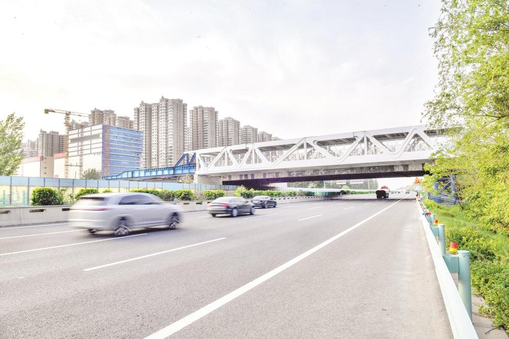 4月23日，由中国一冶承建的人民路跨京港澳高速辅路桥南线钢桁架顶推施工搭设工作顺利完成。 本报记者 李磊 摄