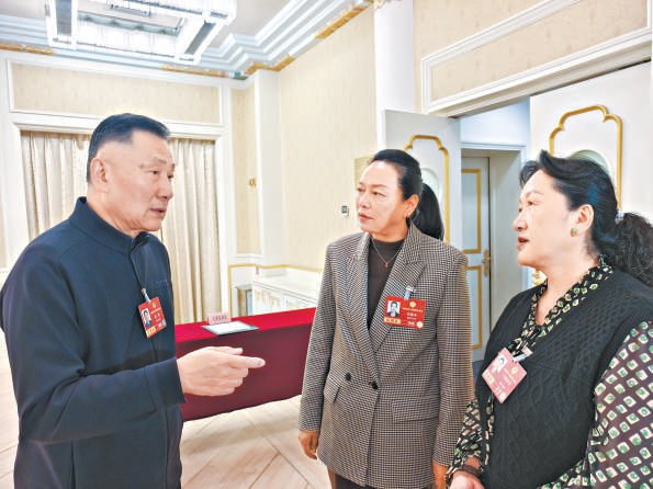 　　会议间隙，霍勇委员（左一）与其他委员交流。 本报记者 孙颖摄