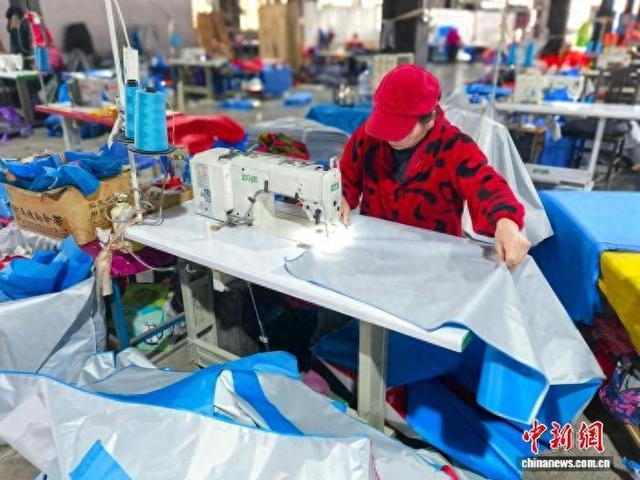 1月14日，湖南绿荫伞业有限公司的厂房内，工人正熟练组装发往非洲的摩托车伞。 张雪盈 摄