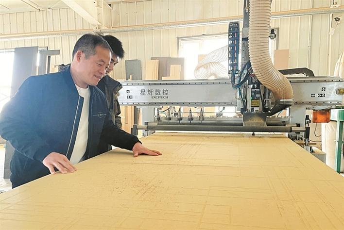 3月25日，在五师双河市中盛家具有限公司生产车间，员工在检查板材质量。 兵团日报常驻记者 张培丽 摄