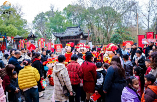 图为游客观看 “财神爷” 巡游表演，现场喜庆热闹。