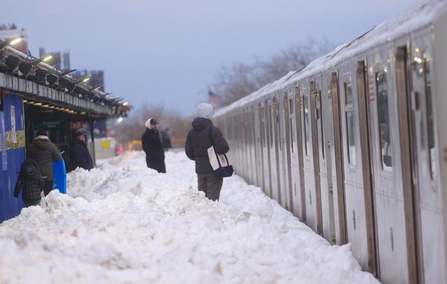 2月23日，美国纽约，乘客们在积雪中等待火车。视觉中国 图